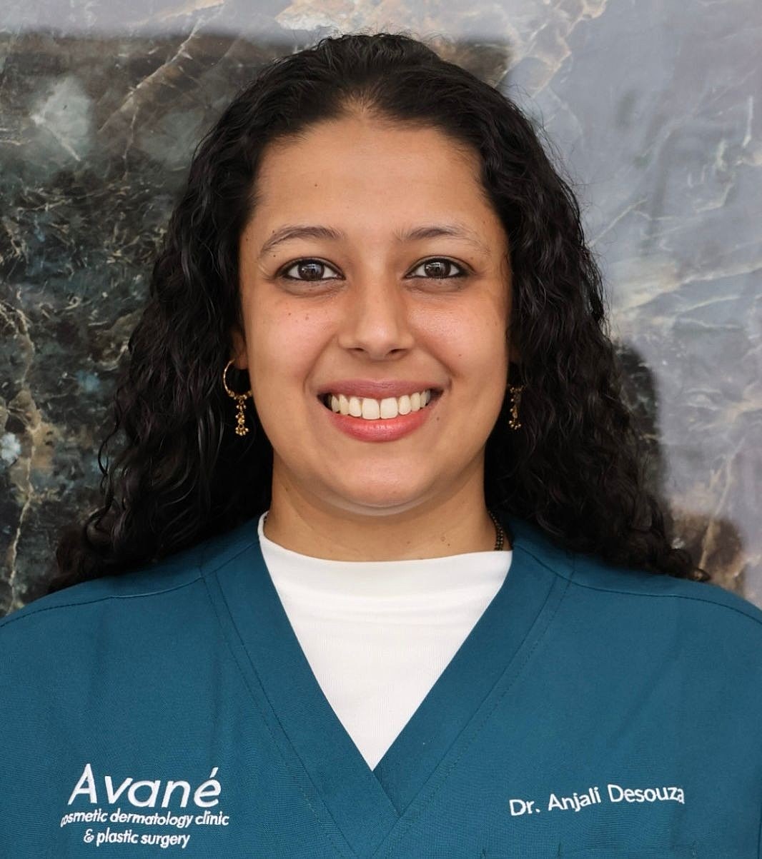 Healthcare professional in black uniform, smiling.
