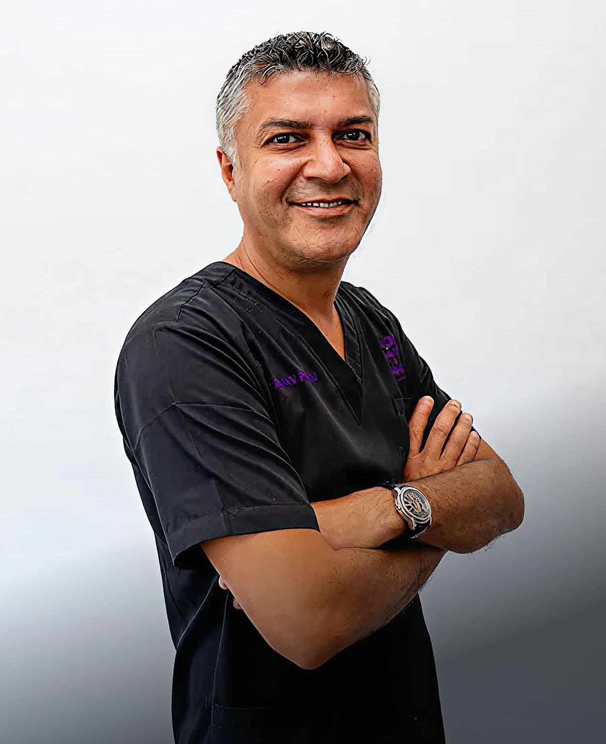 Nairobi Dermatologist Dr. Pranav Pancholi in black medical scrubs.