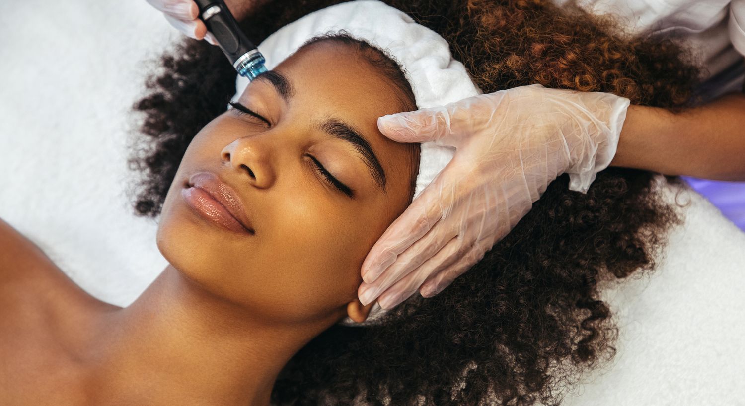 Skincare treatment in progress on a young woman.